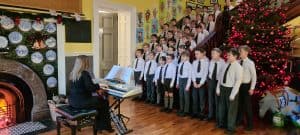 Children singing Christmas carols at Inchmarlo holiday event.