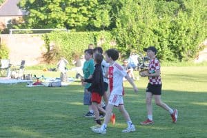 Children playing soccer outdoors in Inchmarlo community park, scenic green landscape in Scotland.