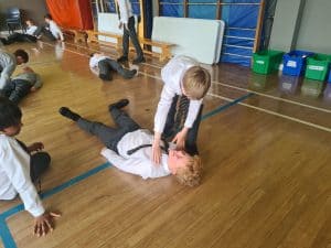 Children practicing safety drills at Inchmarlo School gym.