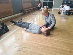 First aid practice session at Inchmarlo, students learning CPR techniques in a classroom.