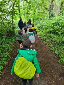Children hiking through lush green woodland at Inchmarlo for outdoor adventure.
