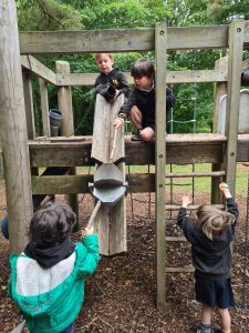 Children playing on outdoor wooden playground at Inchmarlo estate.