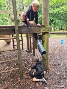 Child playing with telescope at Inchmarlo nature reserve, kids exploring outdoor activities.