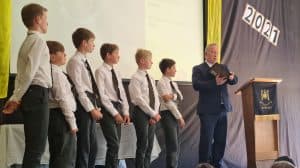 Students in formal attire receiving awards at Inchmarlo School graduation.