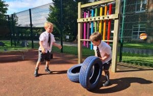 Children enjoying tire obstacle course at Inchmarlo school playground.
