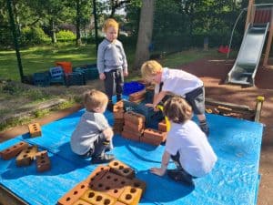 Children playing with large building blocks outdoors at Inchmarlo.