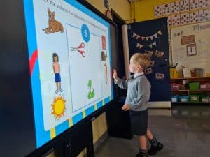 Young boy engaging with digital educational screen at Inchmarlo School.