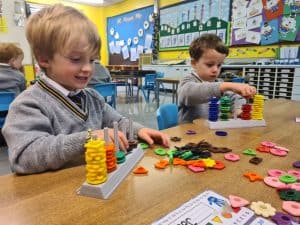 Children playing with educational toys in a classroom setting.