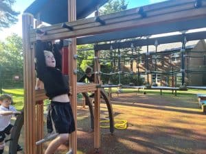 Children playing on outdoor playground equipment at Inchmarlo community park in Scotland.