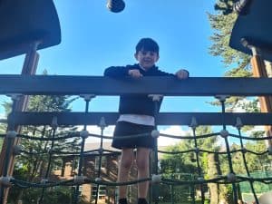 Child playing at Inchmarlo outdoor park in a sunny setting, highlighting family-friendly outdoor activities.
