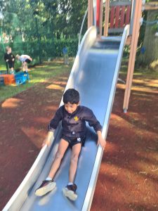 Child sliding down a playground slide at Inchmarlo.