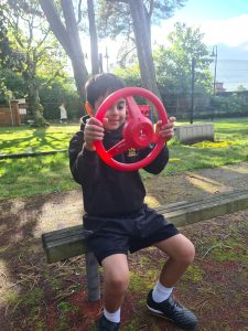Child playing with steering wheel at Inchmarlo park, outdoor fun, family activities in Dundee.