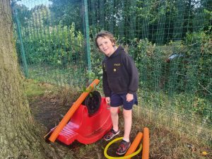 Young boy playing with outdoor gardening tools at Inchmarlo estate.
