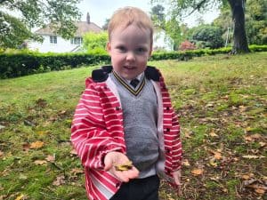 Young boy enjoying outdoor play at Inchmarlo in a lush garden setting.