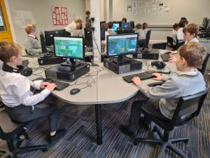 Students using computers in a classroom to enhance digital learning experiences.