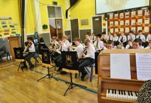 Students playing piano in a school music room, engaging in a music lesson at Inchmarlo.