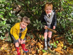 Children exploring nature woods in rain boots.