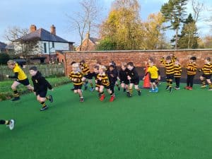 Children playing rugby on outdoor field at Inchmarlo School, outdoor sports and activity fun.