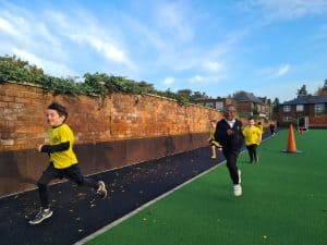 Children running on outdoor sports field at Inchmarlo School.