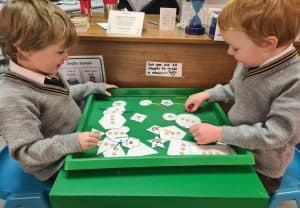 Two children playing with educational cards at Inchmarlo School.