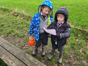 Two children exploring outdoors with maps in hand at Inchmarlo estate.
