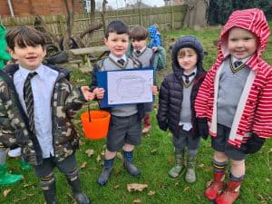 Group of children outdoors at Inchmarlo, smiling and dressed in school uniforms, enjoying a fun activity.