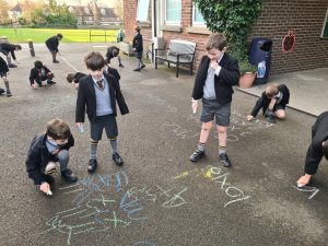 Children drawing with chalk outside Inchmarlo school.