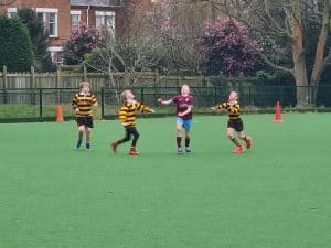 Kids playing rugby at Inchmarlo sports field in Scotland, enjoying outdoor sports and team activities.
