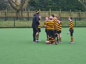 Youth rugby team practicing drills on green field at Inchmarlo.