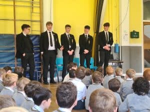 Students giving a presentation at Inchmarlo School in a bright, modern classroom setting.