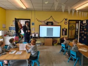 Classroom with children and teacher in a colorful learning environment.
