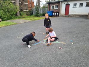 Children playing outdoor at Inchmarlo schoolyard, enjoying arts and crafts.