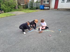 Children drawing with chalk on the driveway at Inchmarlo outdoor activities scene.