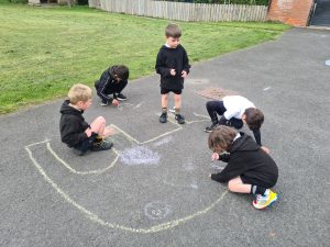 Children playing with chalk on school playground at Inchmarlo.