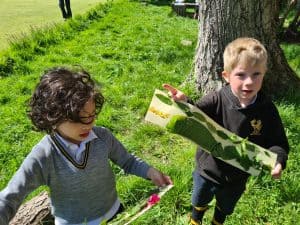 Kids enjoying outdoor activity near a tree in a scenic park setting.