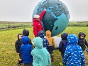 Children exploring Inchmarlo outdoor education site with a giant globe.