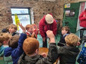 Children engaged in learning at Inchmarlo outdoor education center, fostering teamwork and development.