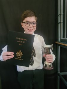 Young girl holding award and trophy at Inchmarlo School event in Scotland.