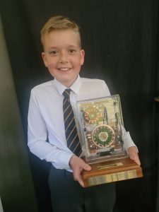 Young boy holding a trophy at Inchmarlo School.