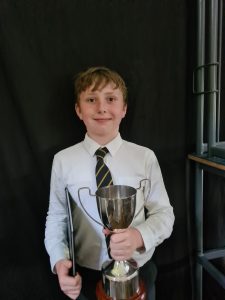Young student holding trophy at Inchmarlo School in Scotland.
