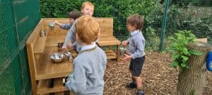 Children playing at Inchmarlo outdoor learning space in a natural environment.