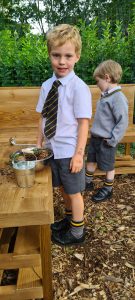 Young boys interacting outdoors at Inchmarlo, enjoying a fun, educational activity.