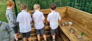 Children explore outdoor play area with natural wooden features.