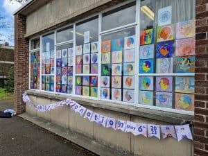 Colorful children's artwork display at Inchmarlo care home. Bright, engaging art celebrating creativity and community.