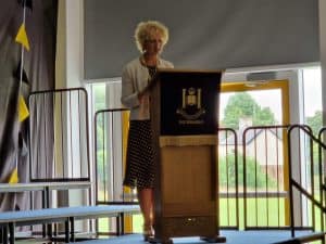 Elegant woman speaking at Inchmarlo community event.