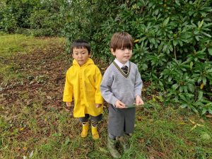 Two children outdoors at Inchmarlo educational nursery, exploring nature and learning.