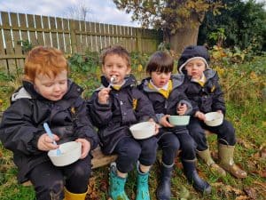 Four children sitting outdoors, enjoying snacks in a garden at Inchmarlo.