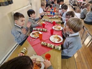 Children enjoying snacks at Inchmarlo residential care, emphasizing community and quality care services.