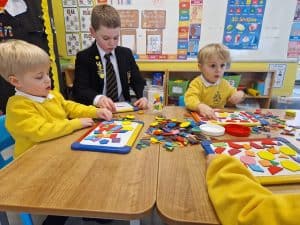 Young children playing with educational toys in a classroom setting.
