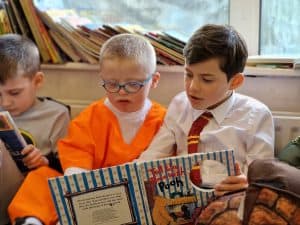 Children reading books at Inchmarlo school, engaging in educational activities.